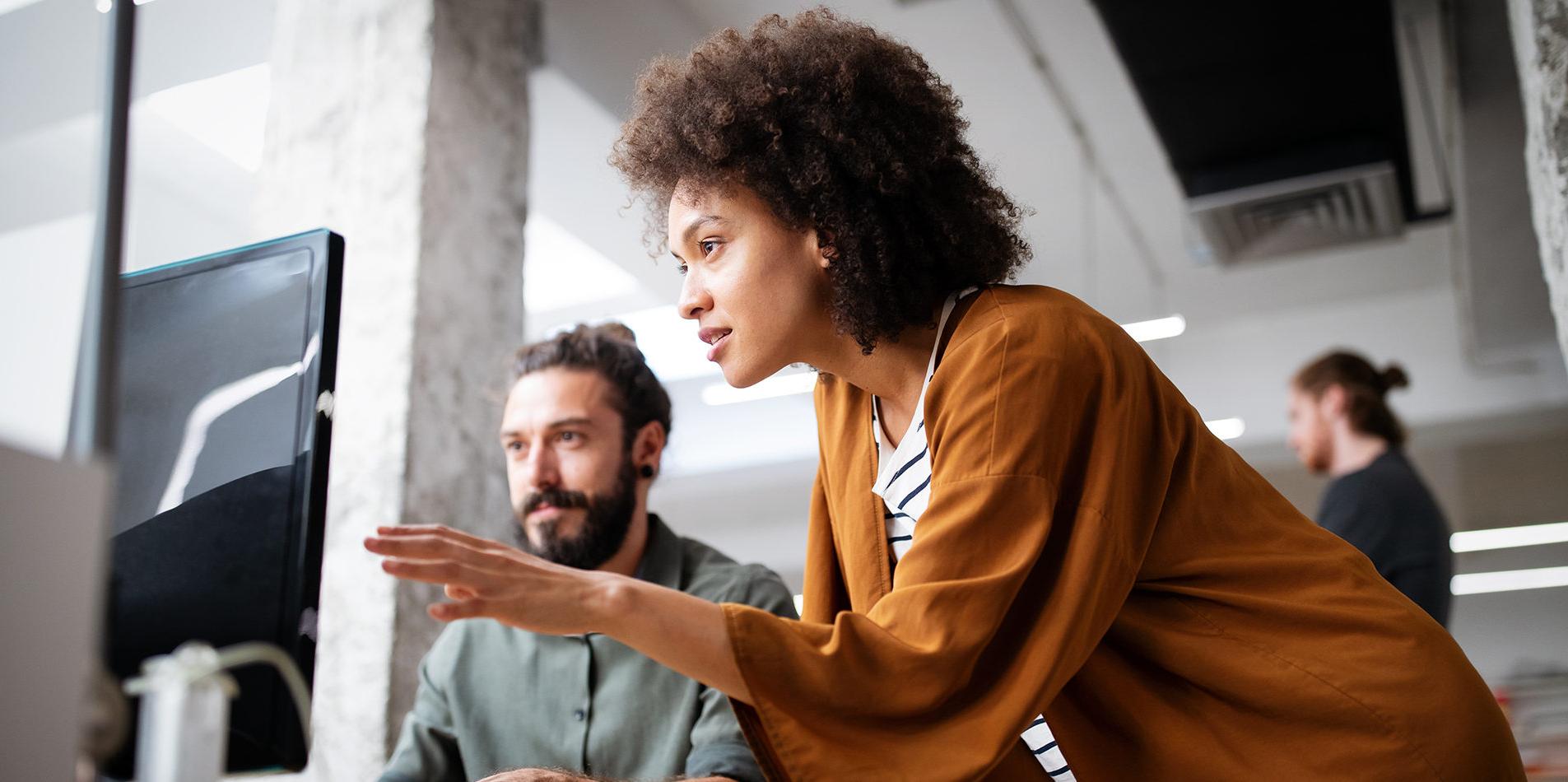 Woman helping man on computer